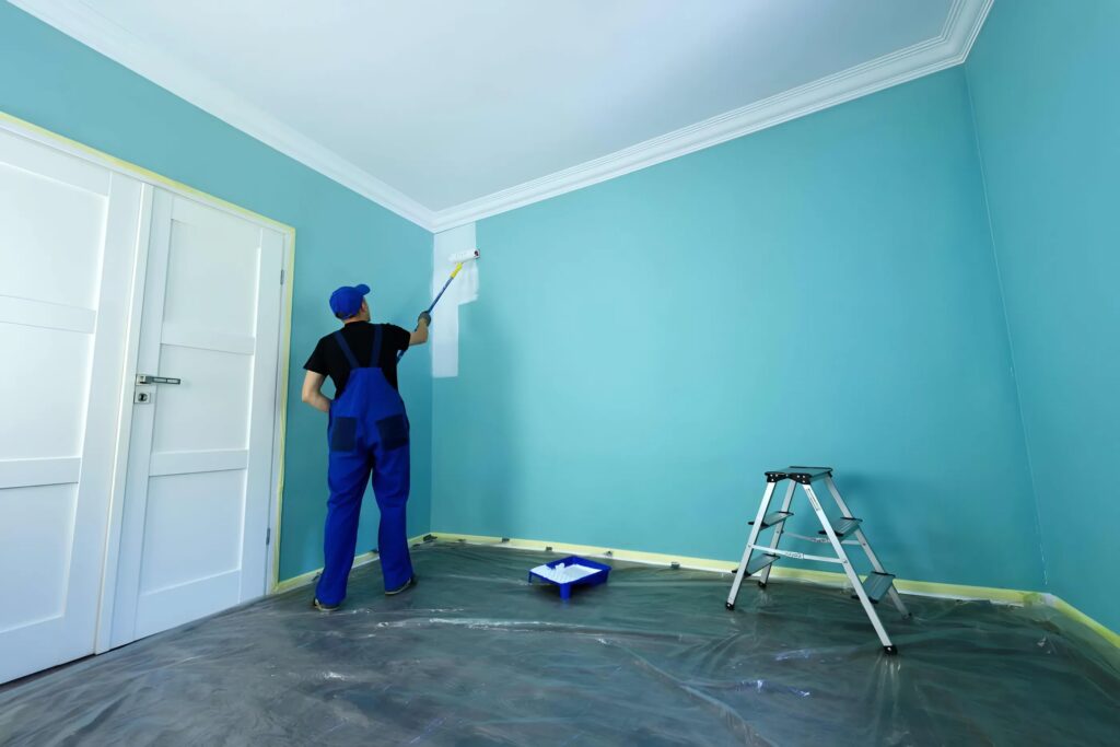 Person painting a vibrant turquoise wall, transforming the room with fresh color and dedication. Project Gallery